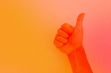 Hand holding a thumbs up.