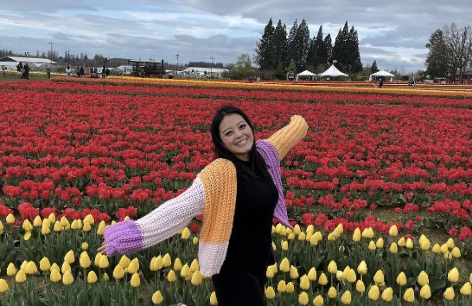 Media Junction team member Mary standing in a field of tulips