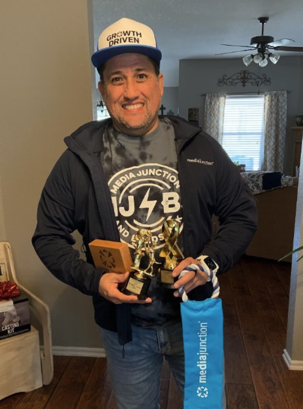 Media Junction team member Oscar holding award trophies